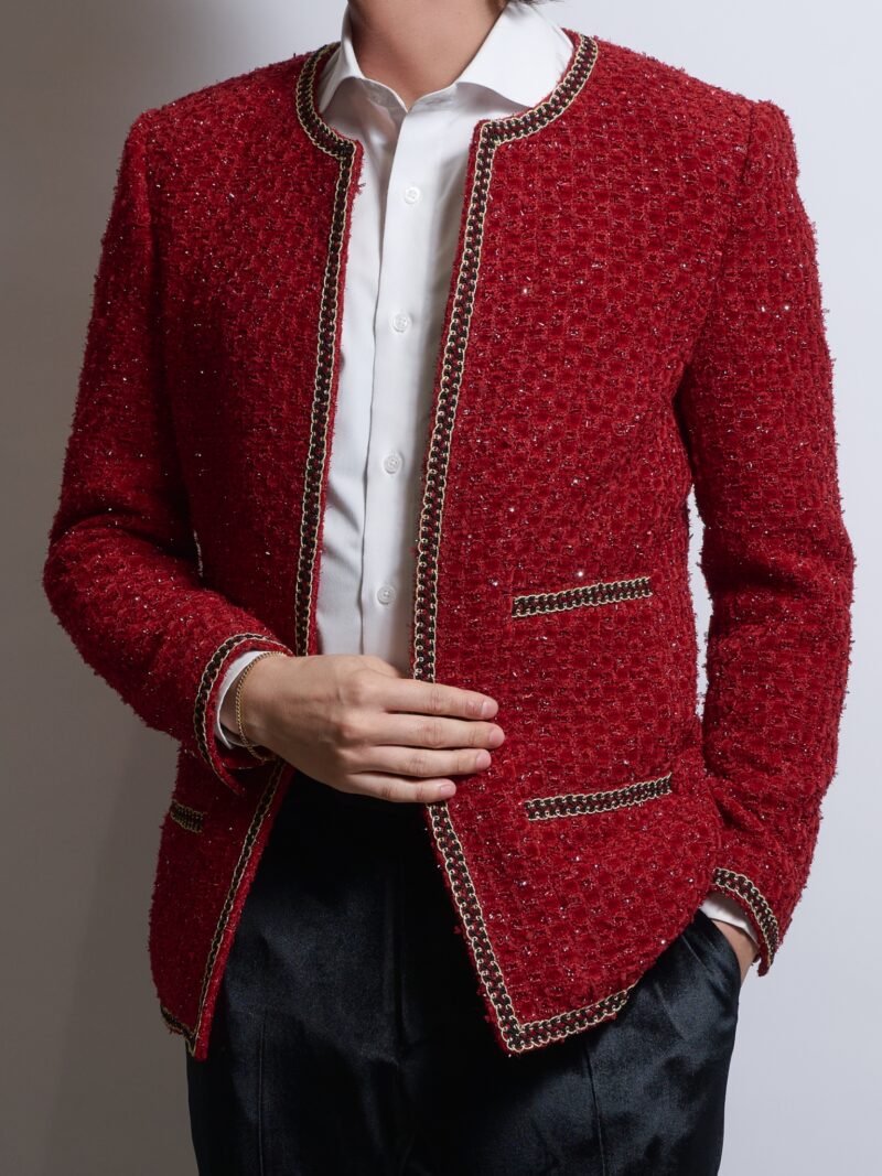 レッドブレークツイードノーカラージャケットを着る男性