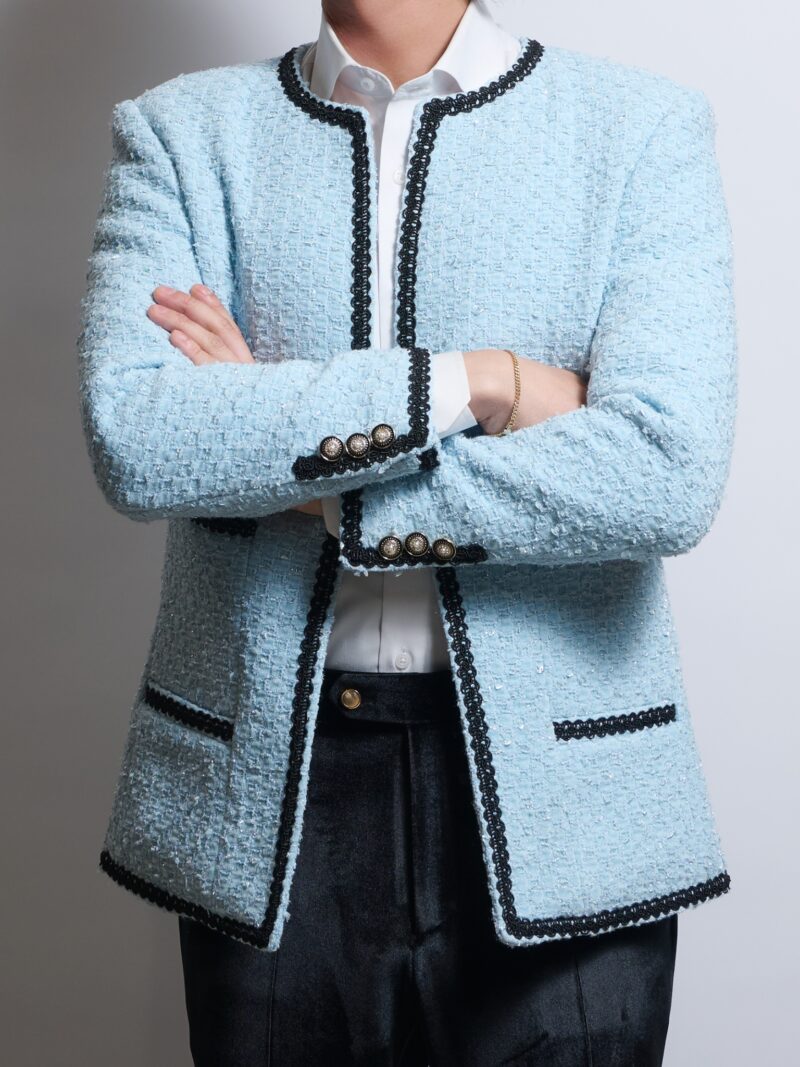 ライトブルーノーカラーブレークツイードジャケットを着る男性