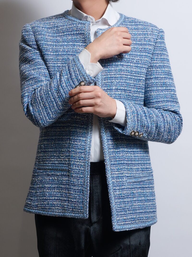 ブークレツイードブルーノーカラージャケットを着る男性