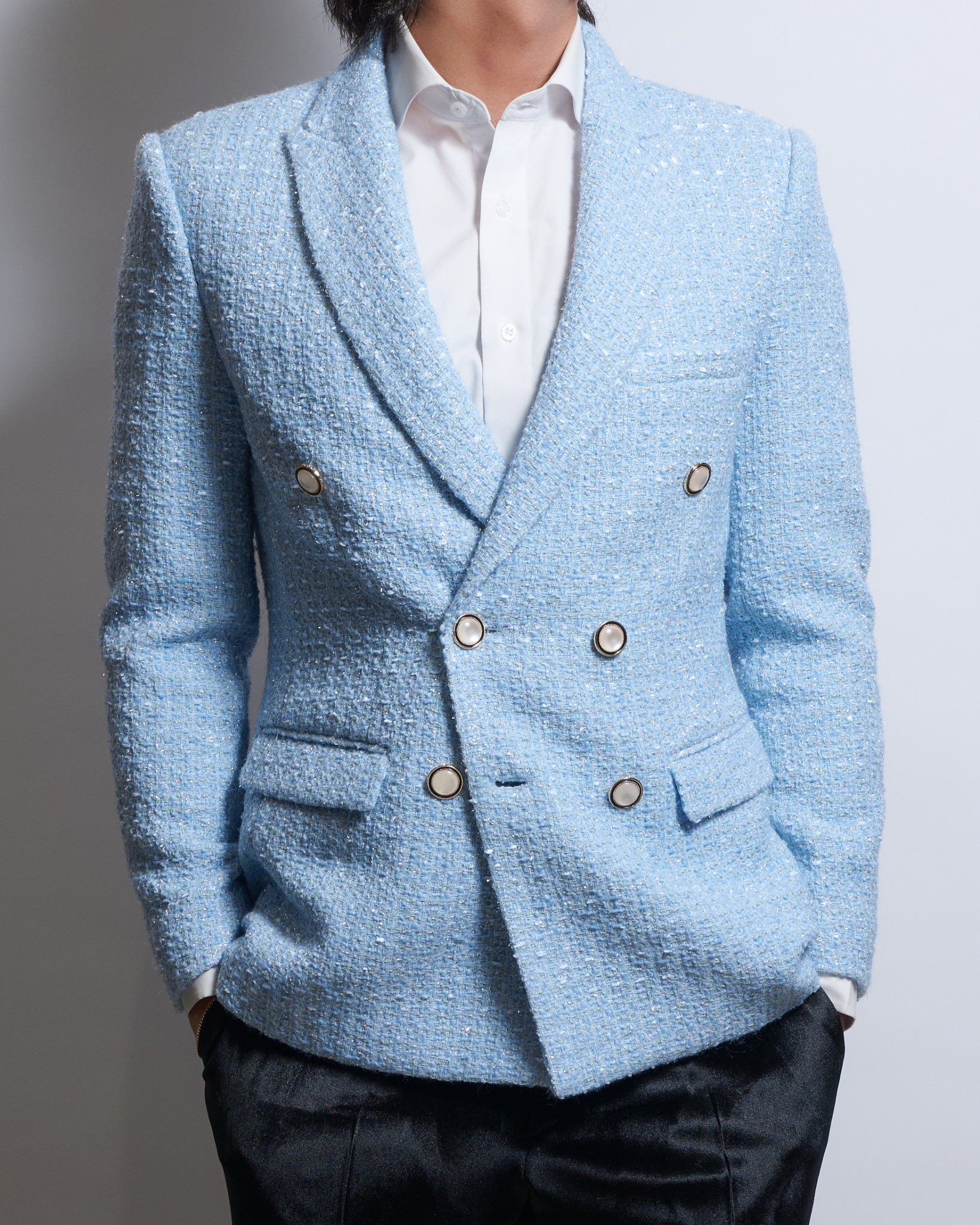 サックスブルーラメツイードダブルジャケットを着る男性