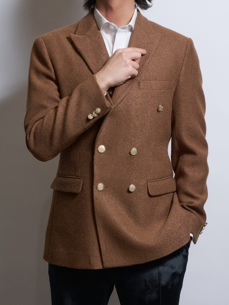 キャメルブラウンダブルジャケットゴールドボタンを着る男性