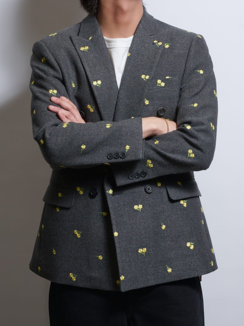 グレーフラワー刺繍ダブルジャケットウールを着る男性