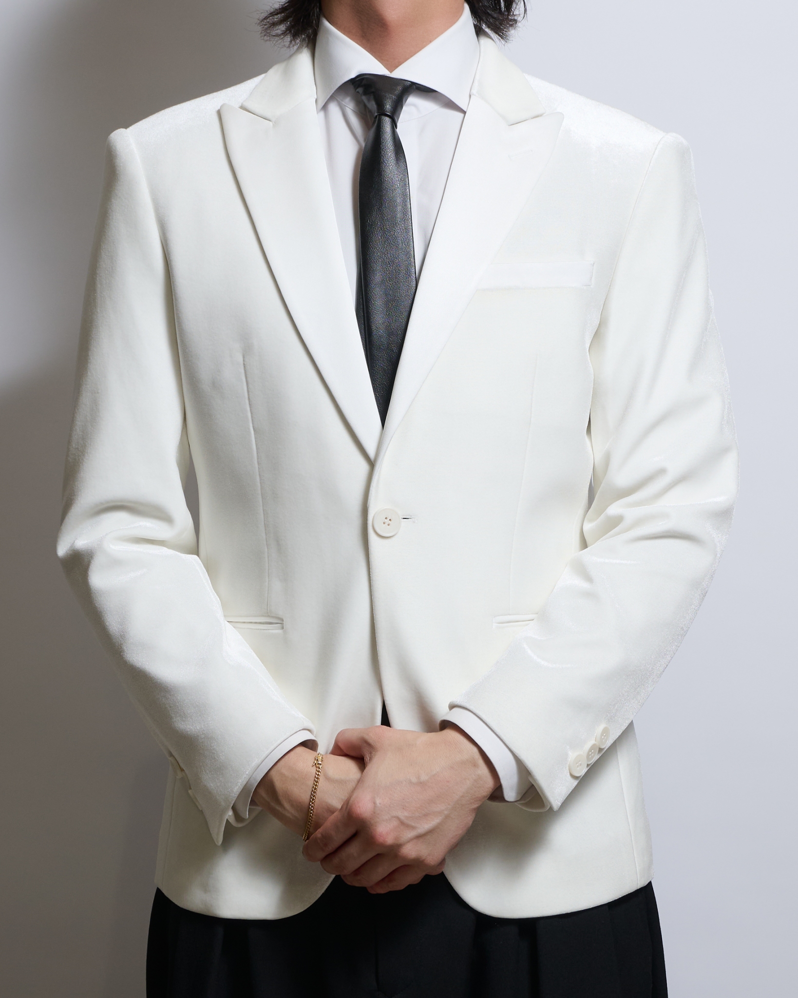 ホワイトベロアシングルジャケットを着る男性