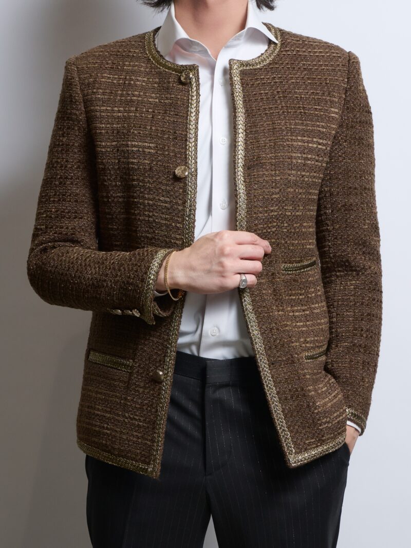 ブラウンノーカラーツイードジャケットラメ入りを着る男性