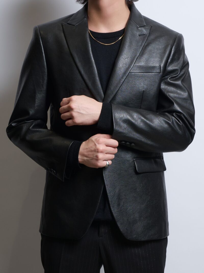 フェイクレザーシングルジャケットを着る男性