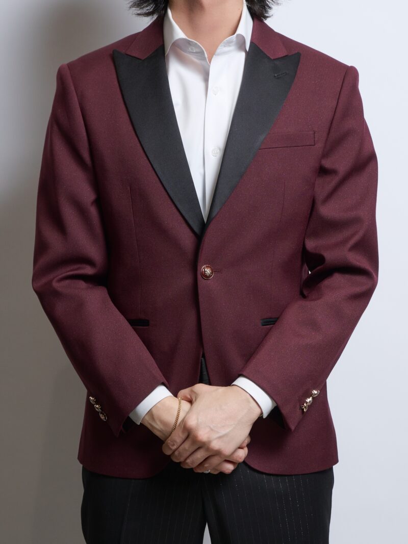 バーガンディーラメ入りシングルジャケット、襟ピークドラペル黒サテンを着る男性